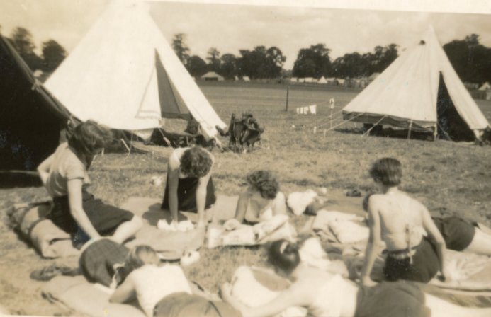 Delwedd o saith o dywyswyr yn torheulo yn y gwersyll