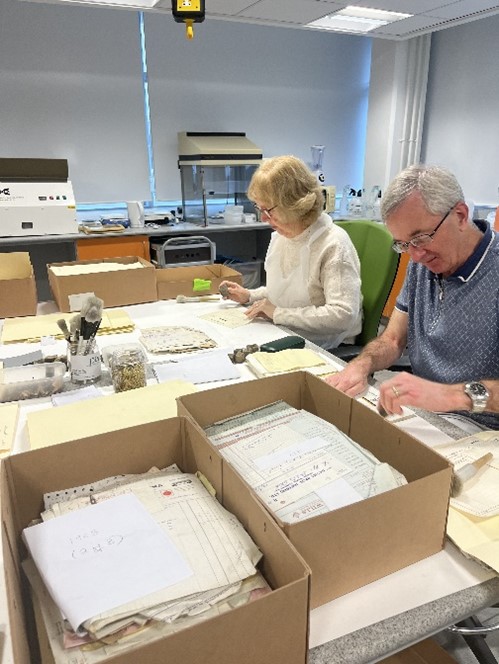 Llun o wirfoddolwyr yn clirio ac yn pecynnu eitemau